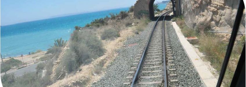 Foto portada capítulo 11. Vías del tren a punto de pasar por un túnel desde la perspectiva del conductor. Al fondo se ve una playa.