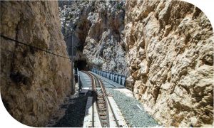 Foto portada capítulo 13. Vías del tren entre rocas montañosas.